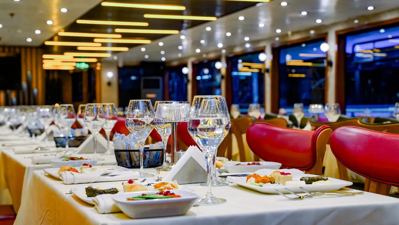 Elegant table setting with wine glasses in the ship's dining hall at night